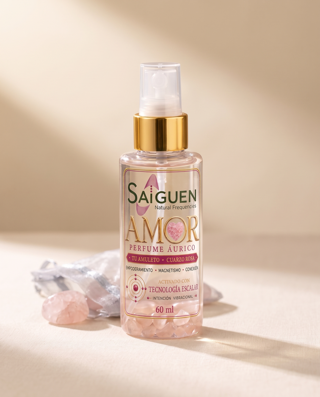 Perfume áurico AMOR de Saiguen con piedritas de cuarzo rosa dentro del frasco, sobre lino crema con cuarzo rosa amuleto y bolsita de organza